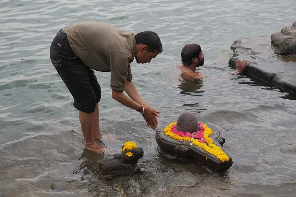 Sacred Shiva Linga decorated with flowers and bilva leaves for Om Namah Shivaya worship